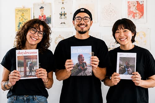 The Kumizine team holding printed zines